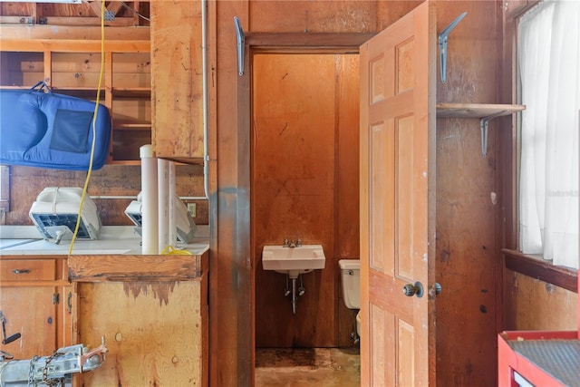 bathroom with concrete flooring, toilet, and sink