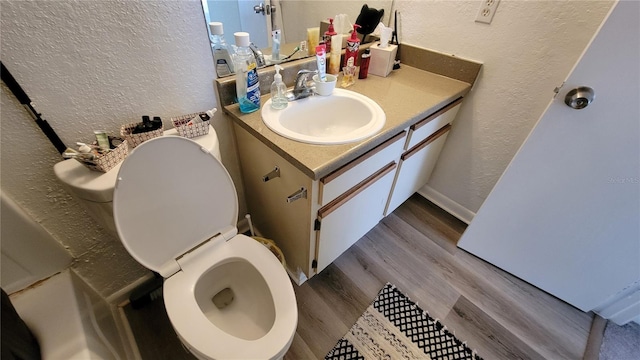 bathroom featuring toilet, vanity, and hardwood / wood-style flooring