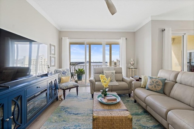 living room with ceiling fan, light hardwood / wood-style floors, and ornamental molding