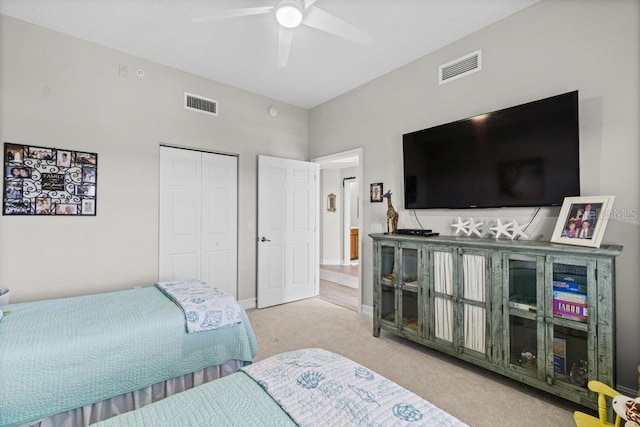 carpeted bedroom with ceiling fan and a closet