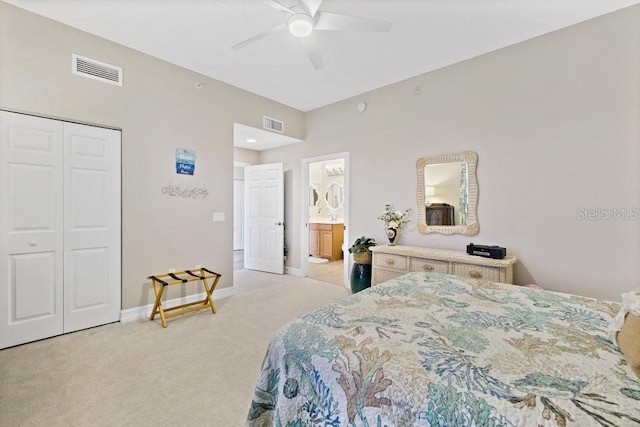 bedroom with ceiling fan, a closet, ensuite bathroom, and light carpet