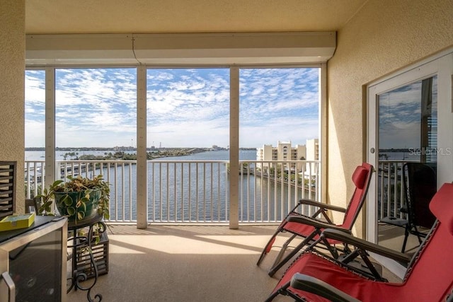 134 Starboard Ln Unit 705, Merritt Island, FL 32953 - sunroom / solarium with a water view, a textured wall, and carpet