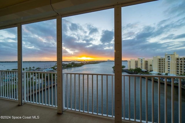 unfurnished sunroom featuring a water view