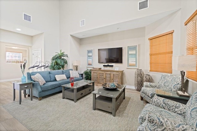 living room with a high ceiling and light hardwood / wood-style floors