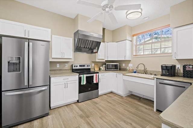 134 Starboard Ln Unit 705, Merritt Island, FL 32953 - kitchen featuring stainless steel appliances, a sink, wall chimney exhaust hood, and white cabinetry