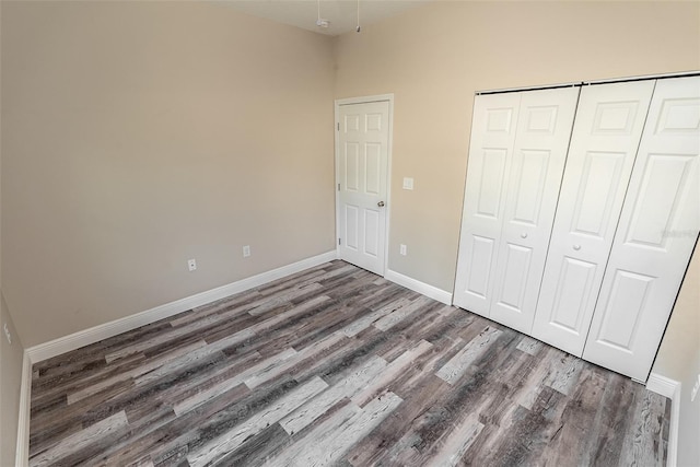 unfurnished bedroom featuring a closet and dark hardwood / wood-style floors