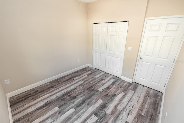 unfurnished bedroom with dark hardwood / wood-style floors and a closet