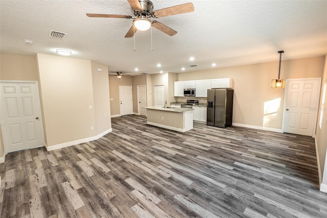 unfurnished living room featuring a textured ceiling, dark hardwood / wood-style flooring, ceiling fan, and sink