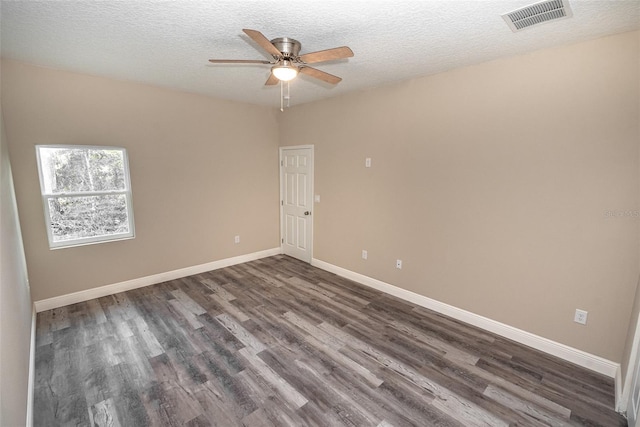 spare room with a textured ceiling, ceiling fan, and dark hardwood / wood-style floors