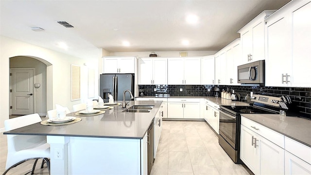 kitchen featuring white cabinets, sink, an island with sink, and stainless steel appliances