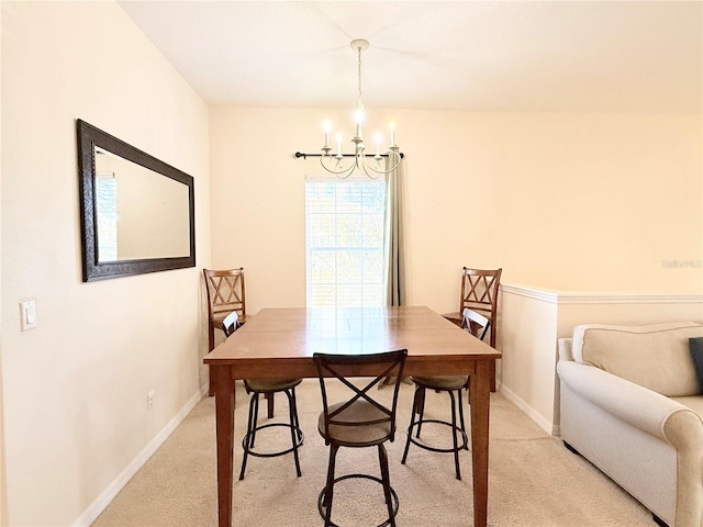 dining area with light carpet and an inviting chandelier