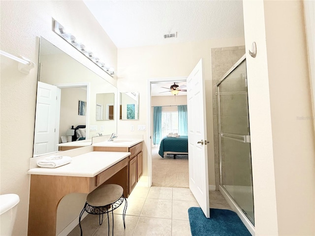 bathroom with tile patterned floors, ceiling fan, a shower with door, and vanity