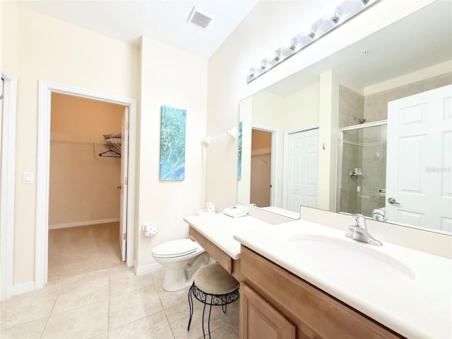 bathroom with toilet, tile patterned flooring, vanity, and walk in shower