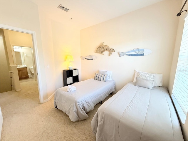 bedroom featuring light carpet and ensuite bathroom