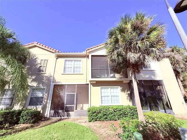 2856 Oakwater Dr Unit 2856, Kissimmee, FL 34747 - view of front of property featuring stucco siding, a tile roof, and a sunroom