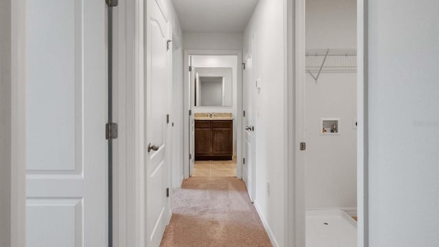 corridor with light colored carpet and sink