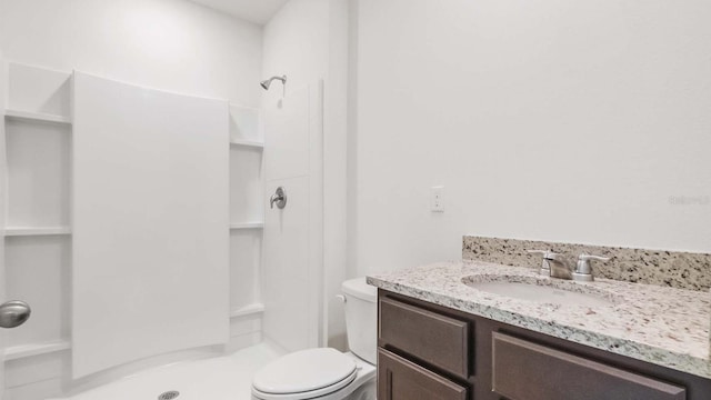 bathroom featuring vanity, toilet, and walk in shower