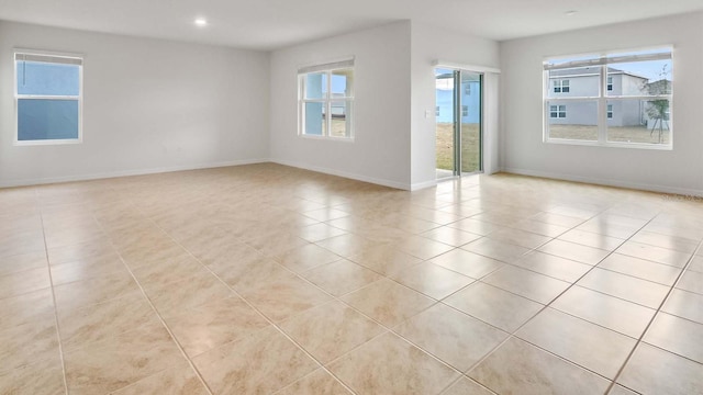 tiled spare room with a healthy amount of sunlight