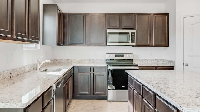 kitchen featuring dark brown cabinets, light tile patterned flooring, sink, and stainless steel appliances