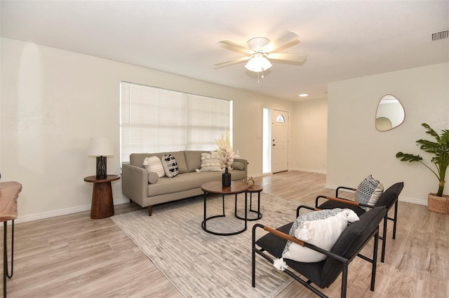 living room with light hardwood / wood-style floors and ceiling fan