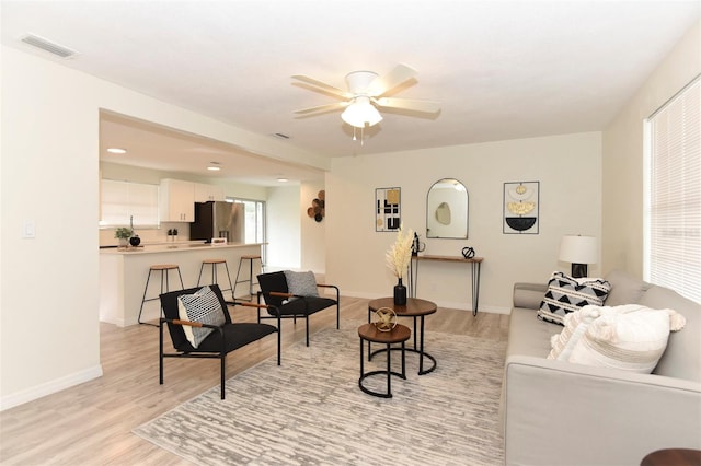 living room featuring light wood-type flooring and ceiling fan