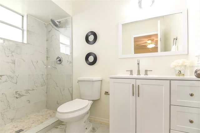 bathroom featuring a tile shower, vanity, and toilet