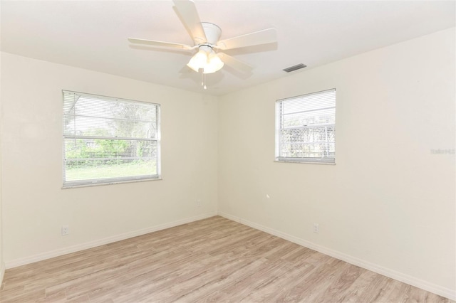 unfurnished room with a wealth of natural light, ceiling fan, and light hardwood / wood-style floors