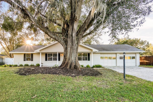 ranch-style home featuring a garage and a front lawn