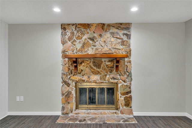 interior details featuring a fireplace, a textured ceiling, and hardwood / wood-style flooring