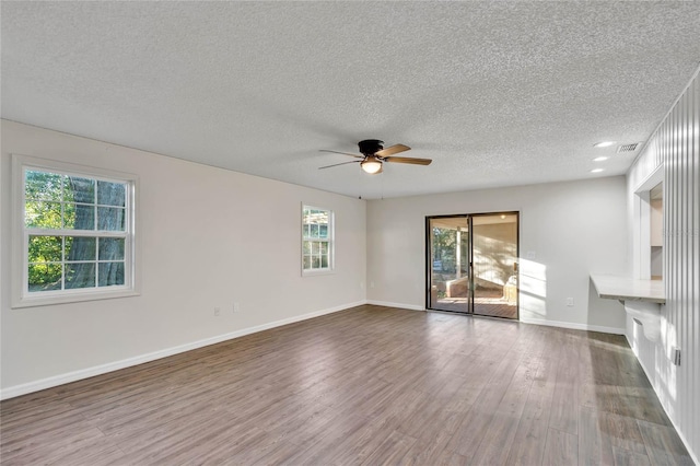 unfurnished living room with wood-type flooring, a textured ceiling, and ceiling fan