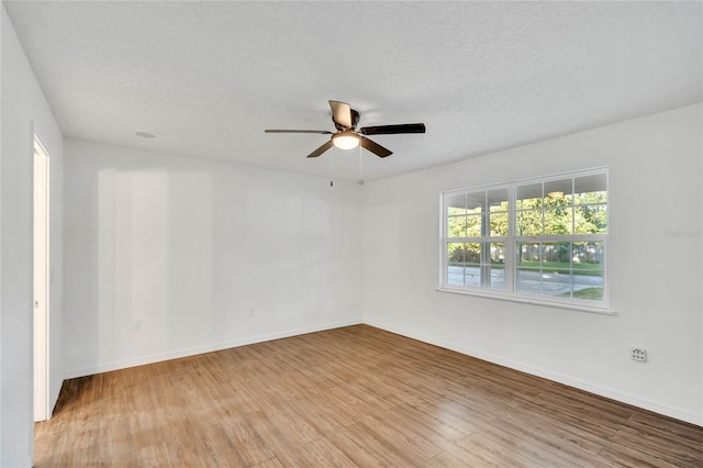 spare room featuring ceiling fan, light hardwood / wood-style floors, and a textured ceiling