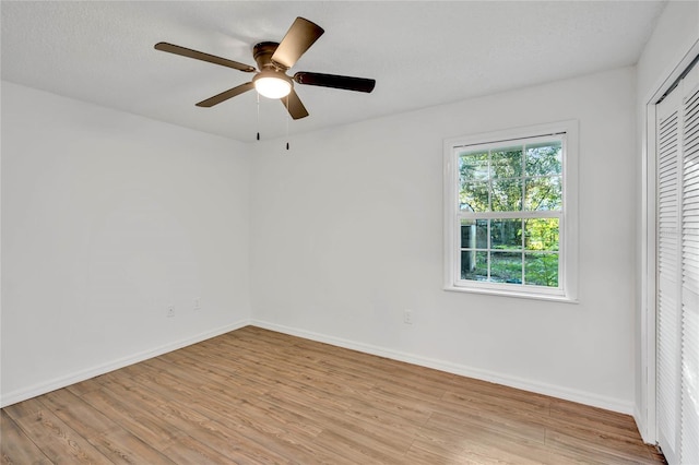 unfurnished bedroom featuring ceiling fan, a closet, a textured ceiling, and light hardwood / wood-style flooring