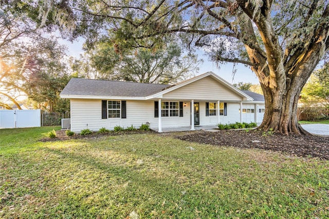 ranch-style house with covered porch, cooling unit, and a front yard