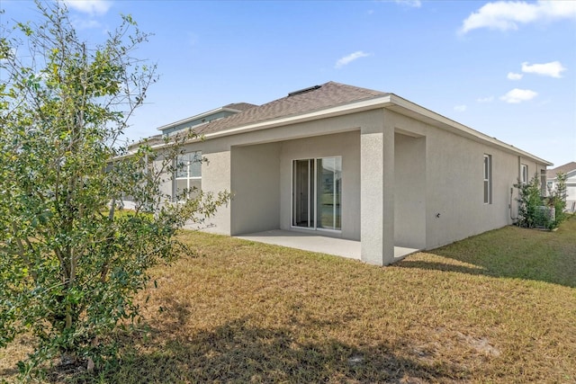 back of house featuring a lawn and a patio