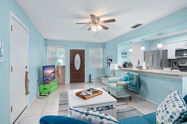 tiled living room with ceiling fan and sink