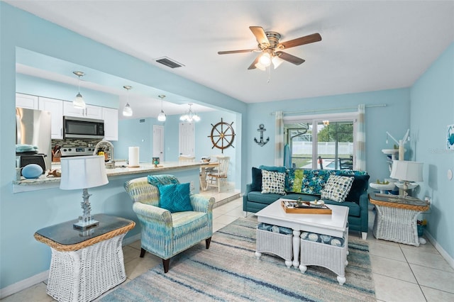 living room with ceiling fan with notable chandelier and light tile patterned floors