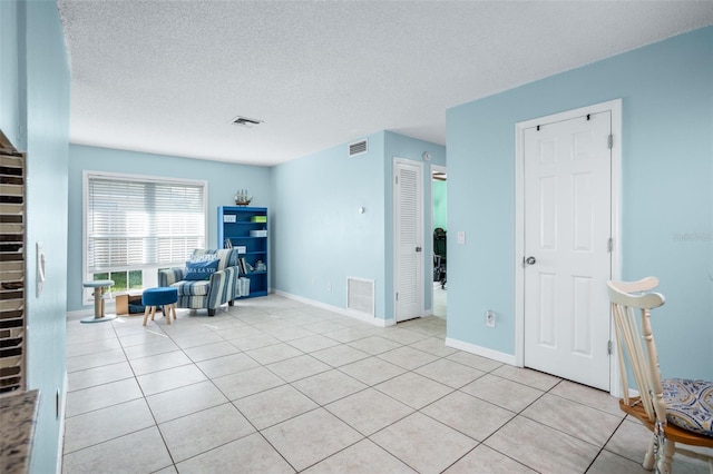 unfurnished room with light tile patterned floors and a textured ceiling