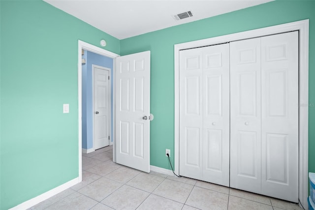 unfurnished bedroom with light tile patterned floors and a closet