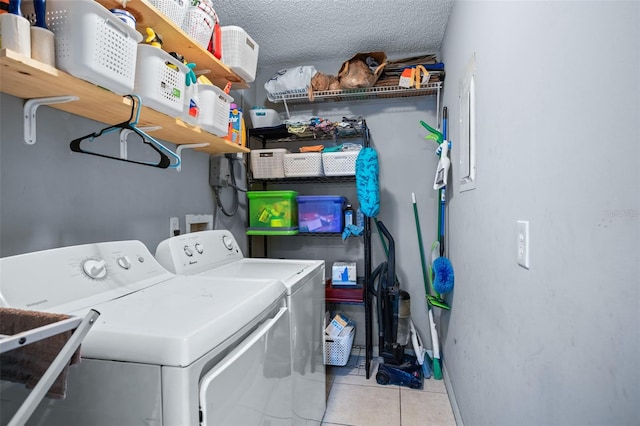 laundry room with washer and dryer, light tile patterned floors, a textured ceiling, and sink