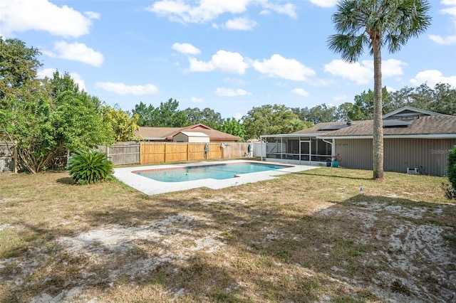 view of pool with a sunroom and a lawn