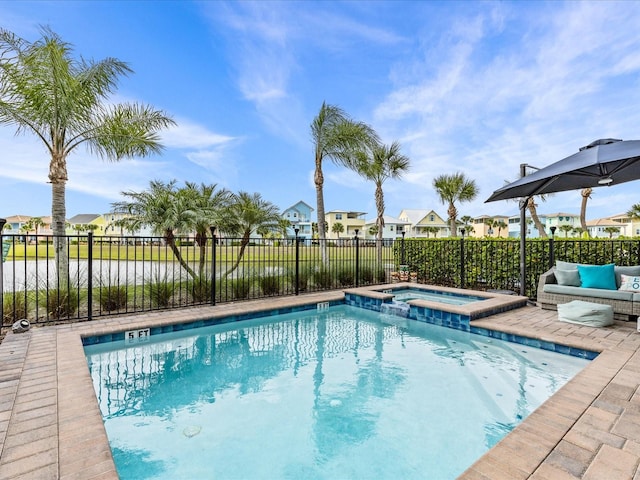 view of swimming pool featuring a patio area, an in ground hot tub, and a water view