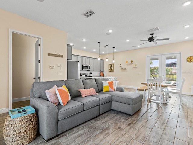 living room featuring ceiling fan, light hardwood / wood-style floors, and french doors