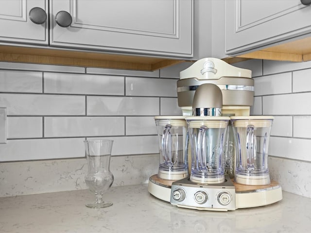 details featuring white cabinetry and light stone countertops