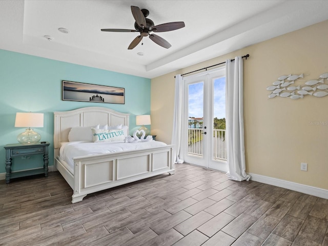 bedroom featuring access to exterior, french doors, a raised ceiling, ceiling fan, and light hardwood / wood-style floors