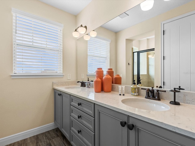 bathroom with hardwood / wood-style flooring, vanity, and an enclosed shower