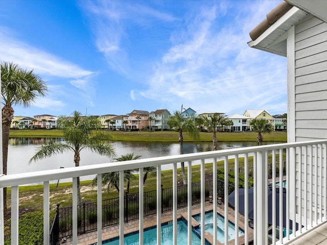 exterior space featuring an in ground hot tub and a water view