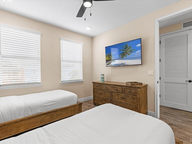 bedroom with wood-type flooring, a closet, and ceiling fan