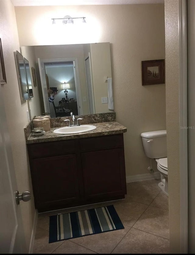 bathroom with tile patterned floors, vanity, and toilet