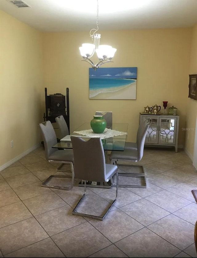 tiled dining space featuring a chandelier