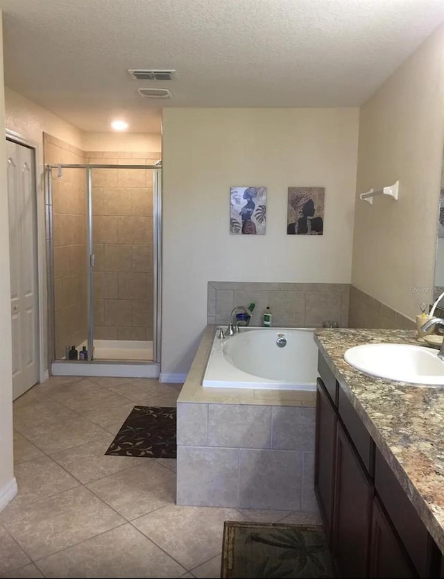 bathroom featuring tile patterned flooring, a textured ceiling, vanity, and independent shower and bath